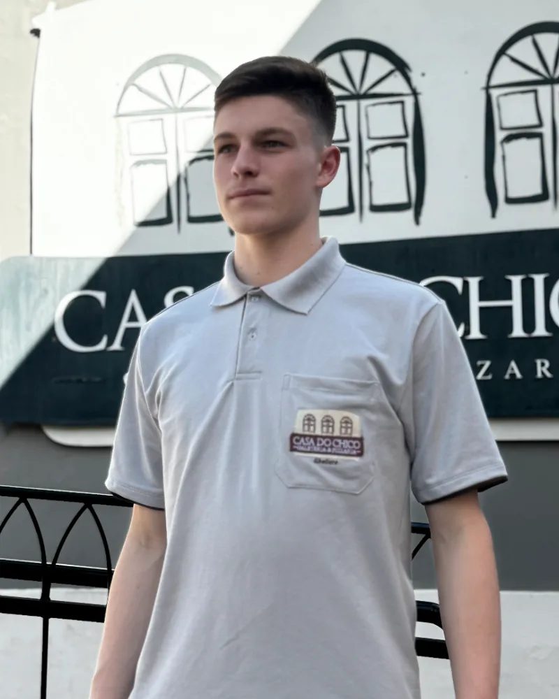 Colaborador com polo cinza personalizada com logo bordado no bolso